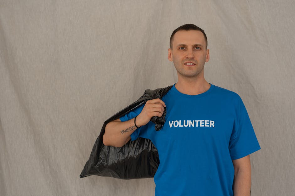 Denali Area Volunteer Day — June 12, 2026 — Volunteer in blue shirt holding a garbage bag during a cleanup effort.