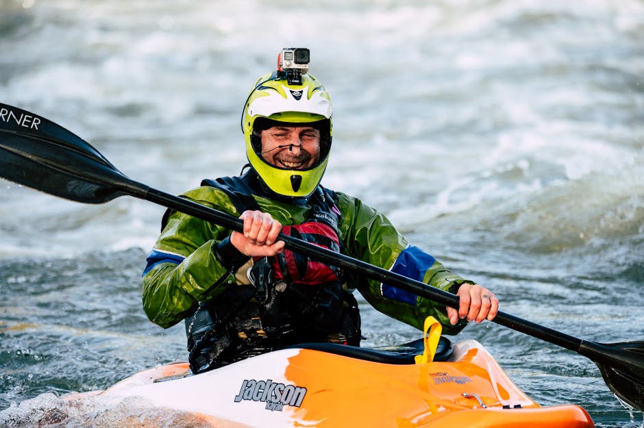 Southeast Alaska Kayaking Trip — August 14, 2026 — Man engaged in kayaking on river rapids, wearing colorful gear and helmet with action camera.